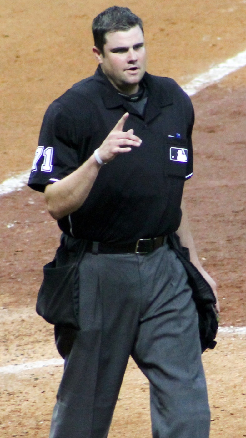 A Major League home-plate umpire signaling to players after a call