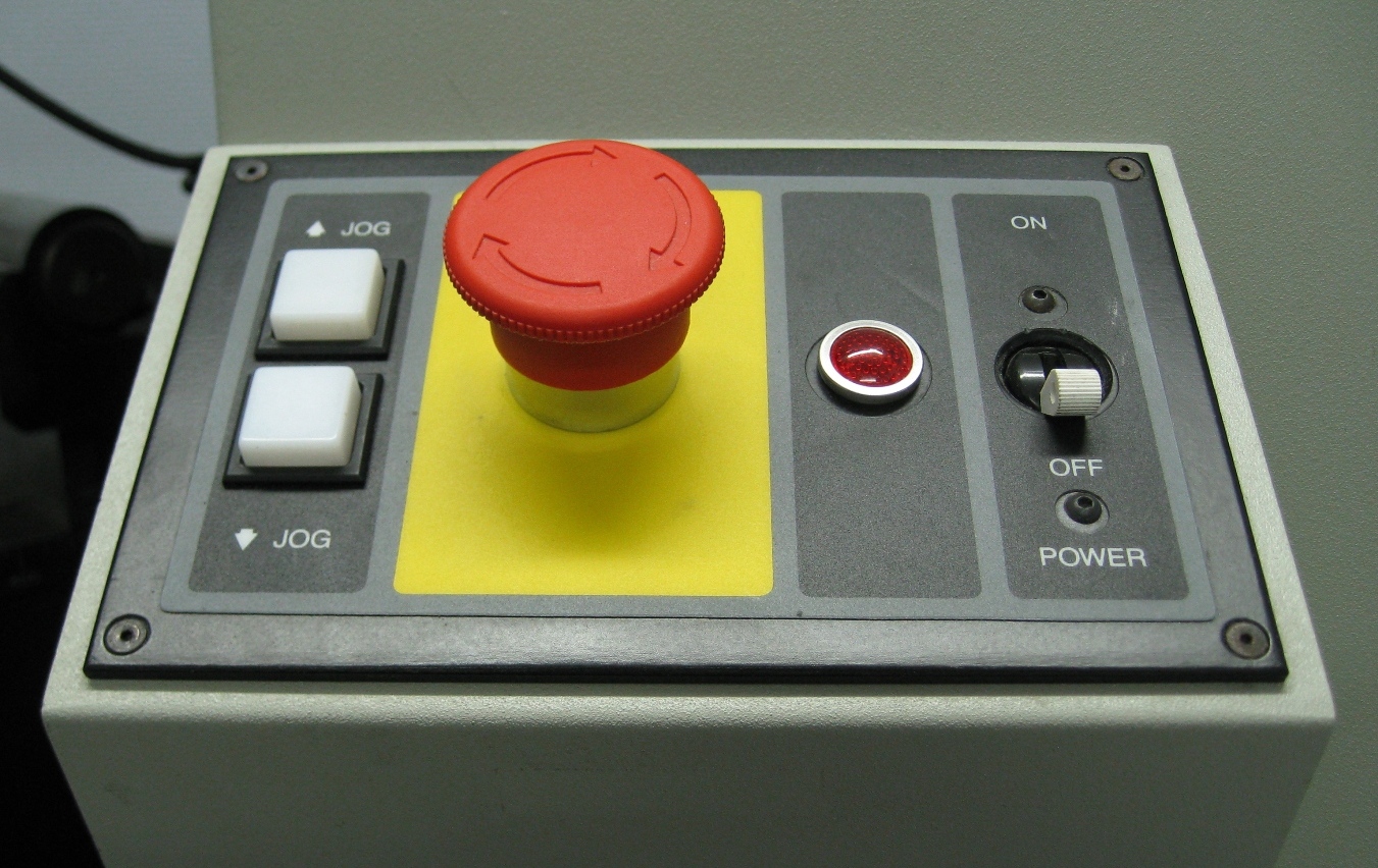 A red emergency stop button mounted on industrial equipment, symbolizing a physical kill switch