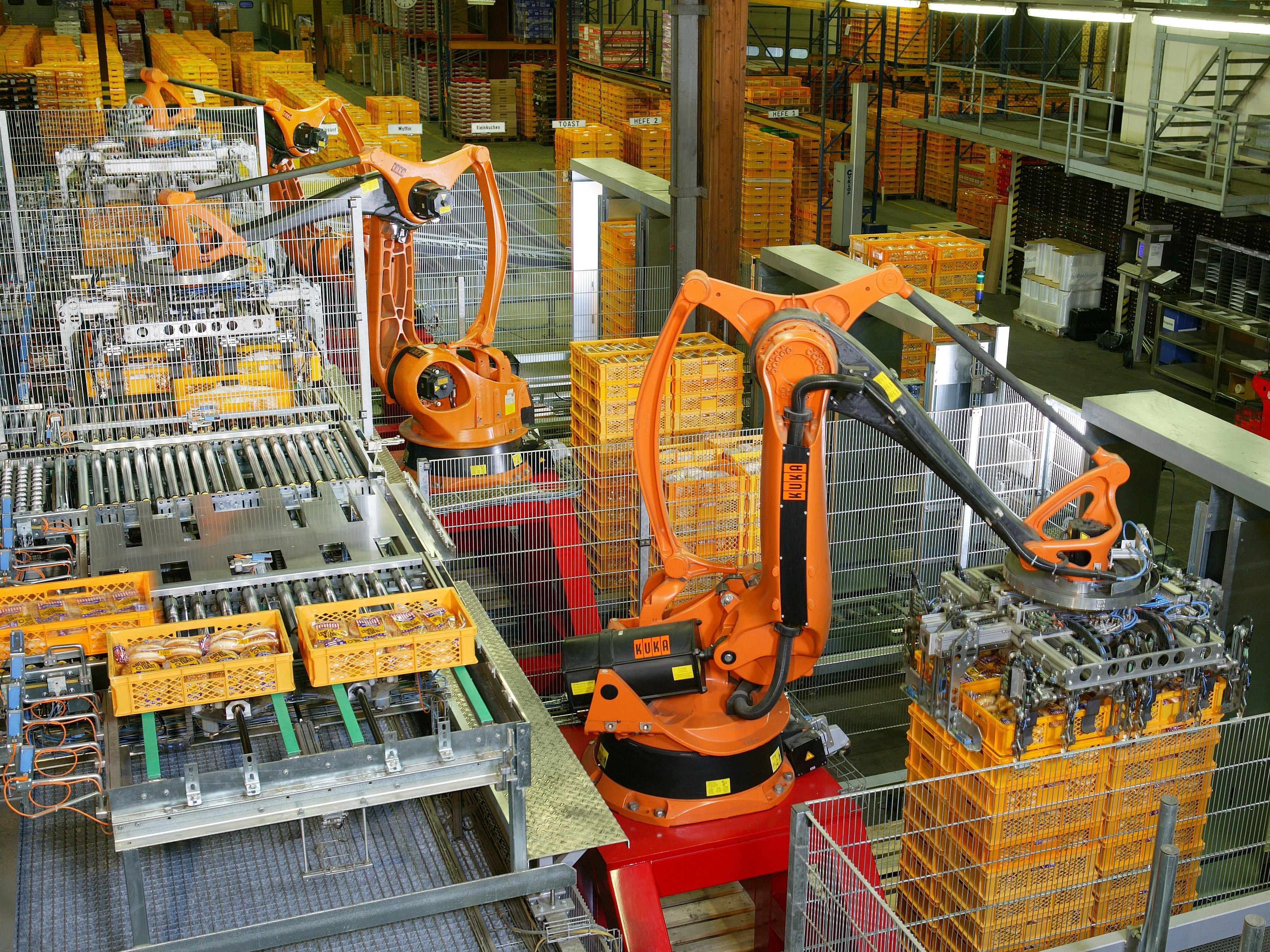KUKA industrial robot arms automate bread palletizing at a German bakery — automation has reshaped factory floors for decades yet its measured employment impact consistently defies the alarm