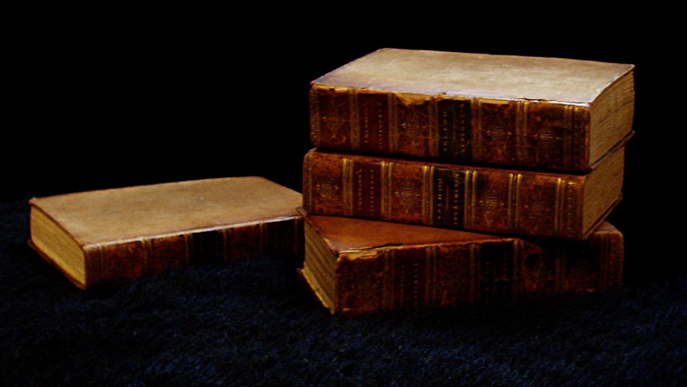 Several leather-bound antique printed books — illustrating pre-2022 print copies treated as raw material for AI training
