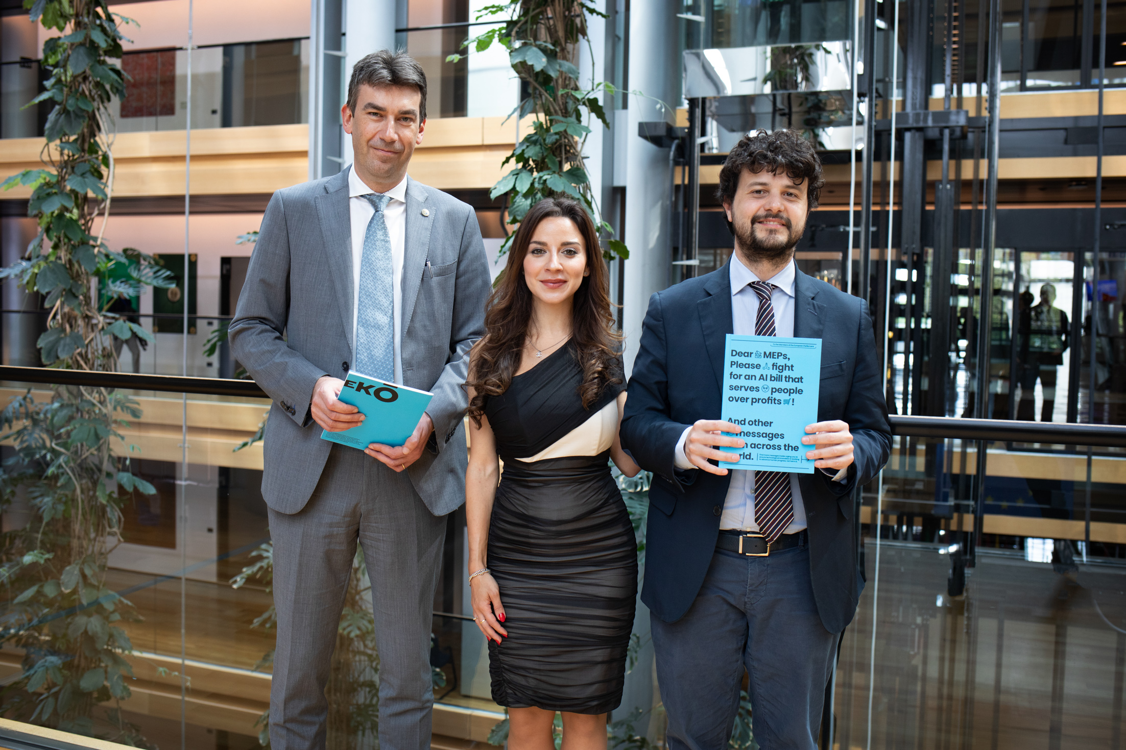 Advocates at the EU Parliament in Strasbourg holding booklets calling for AI Act legislation — a campaign demanding AI that serves people