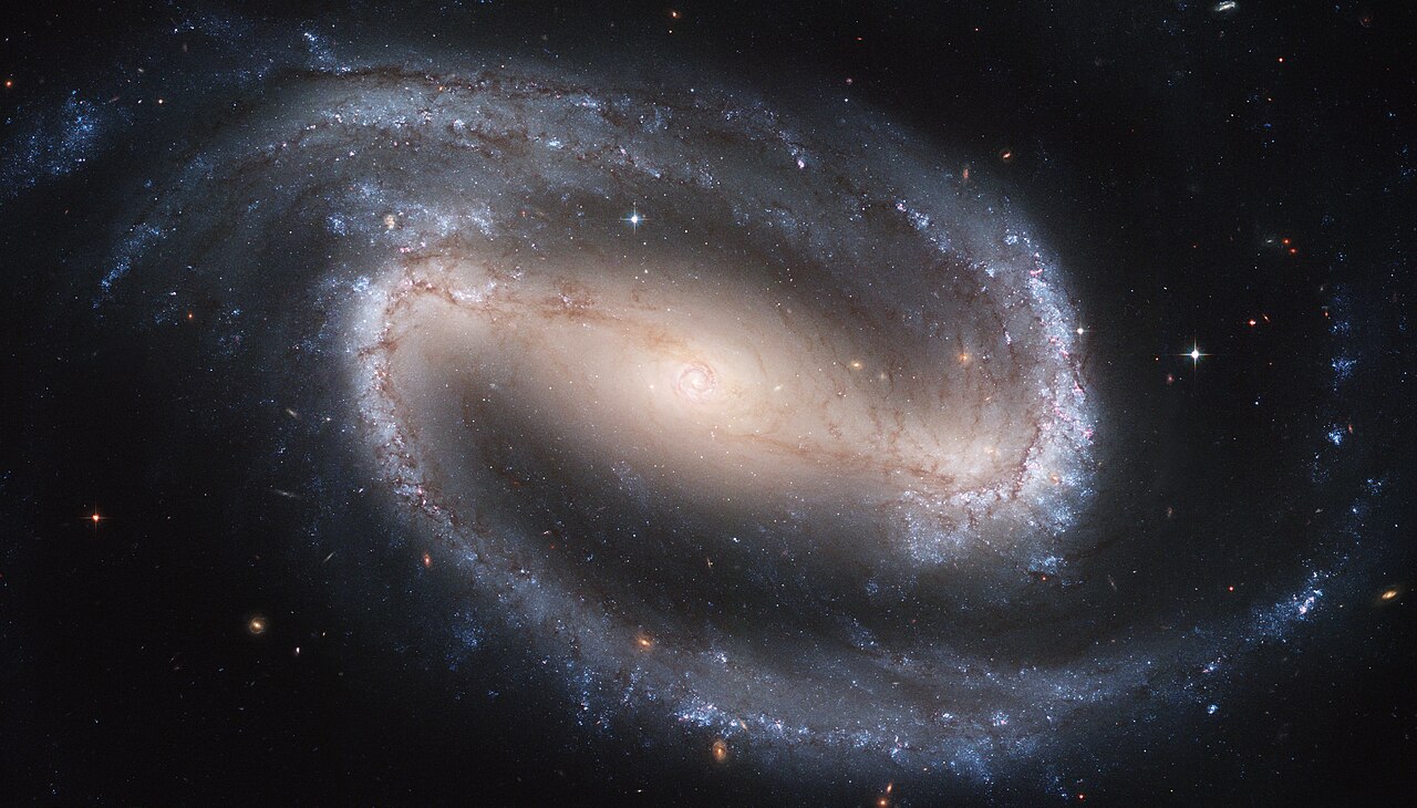 Hubble Space Telescope image of the barred spiral galaxy NGC 1300, showing a straight bar running through the galaxy's centre with spiral arms unwinding from its ends