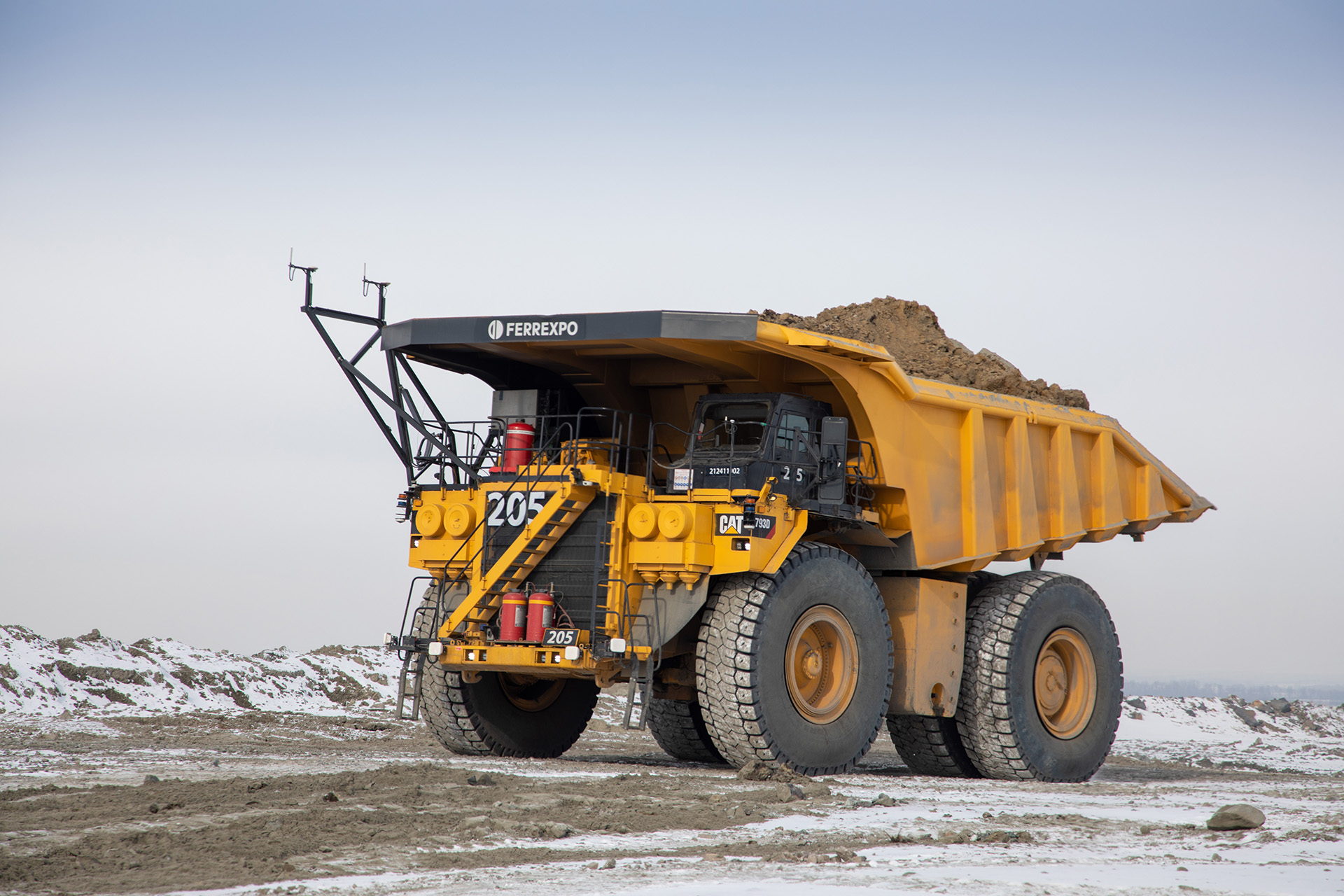 A Caterpillar CAT 793D autonomous haul truck fitted with a sensor mast, hauling material at a mine
