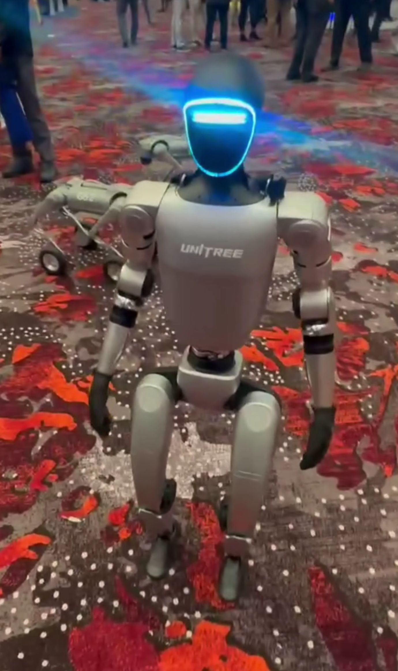 Unitree G1 humanoid robot on display — a bipedal robot with the UNITREE logo, shown at a public demonstration