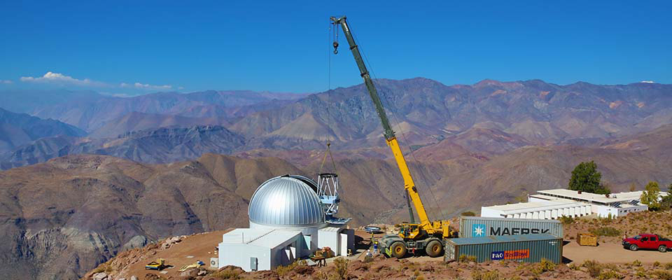 A crane installing a KMTNet telescope dome at the CTIO site in Chile in 2014