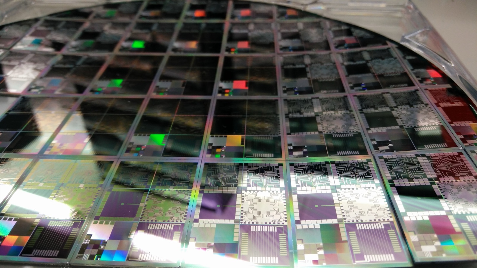A 12-inch semiconductor wafer with dies laid out in a grid, evoking pre-EDA chip design