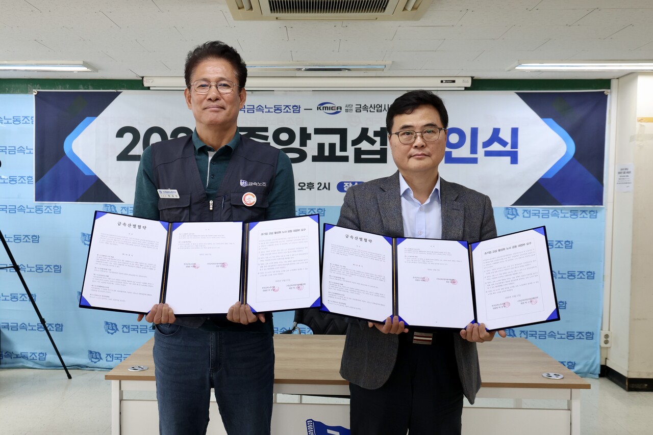 박상만 전국금속노동조합 위원장과 박근형 금속산업사용자협의회 회장이 금속산별협약 조인식에서 합의안을 들고 있는 모습
