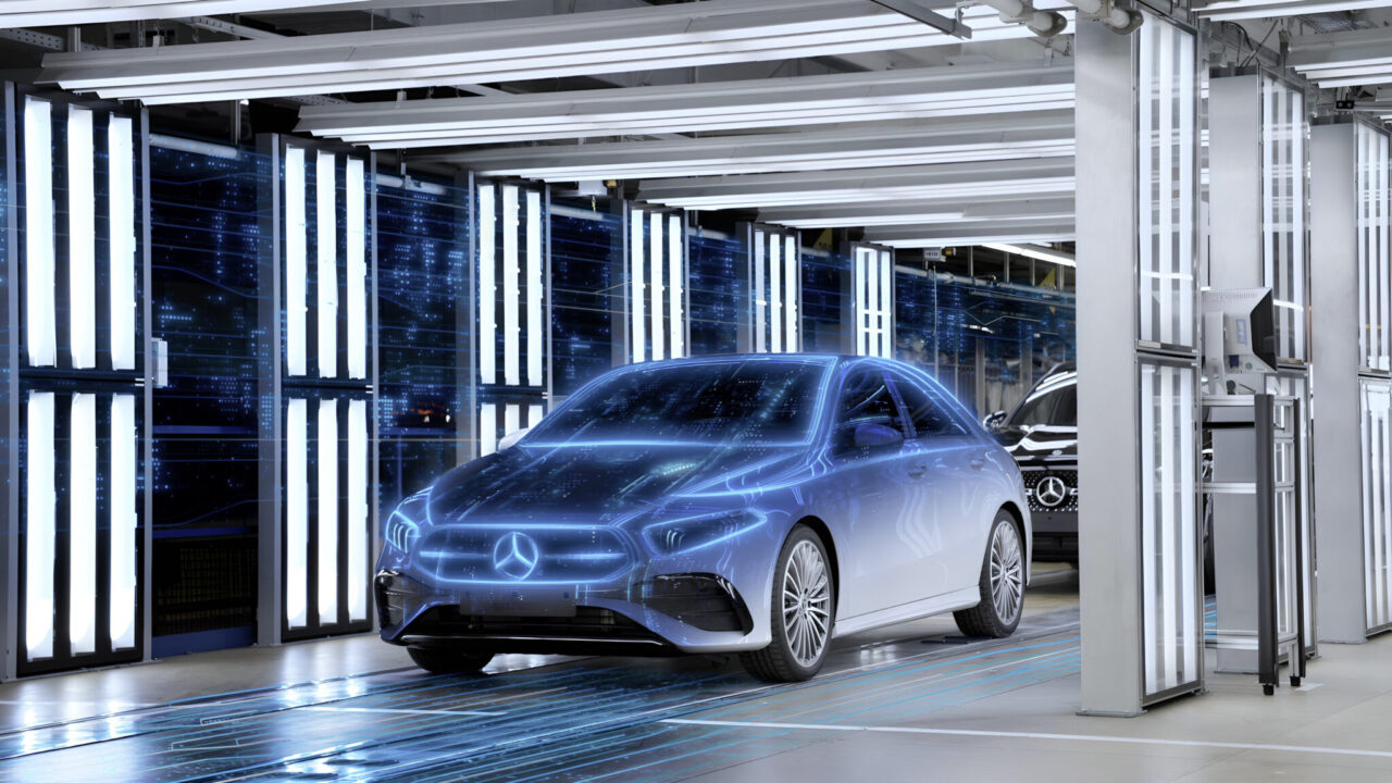 Mercedes-Benz vehicle with blue digital twin overlay inside a factory — MO360 digital ecosystem visualization