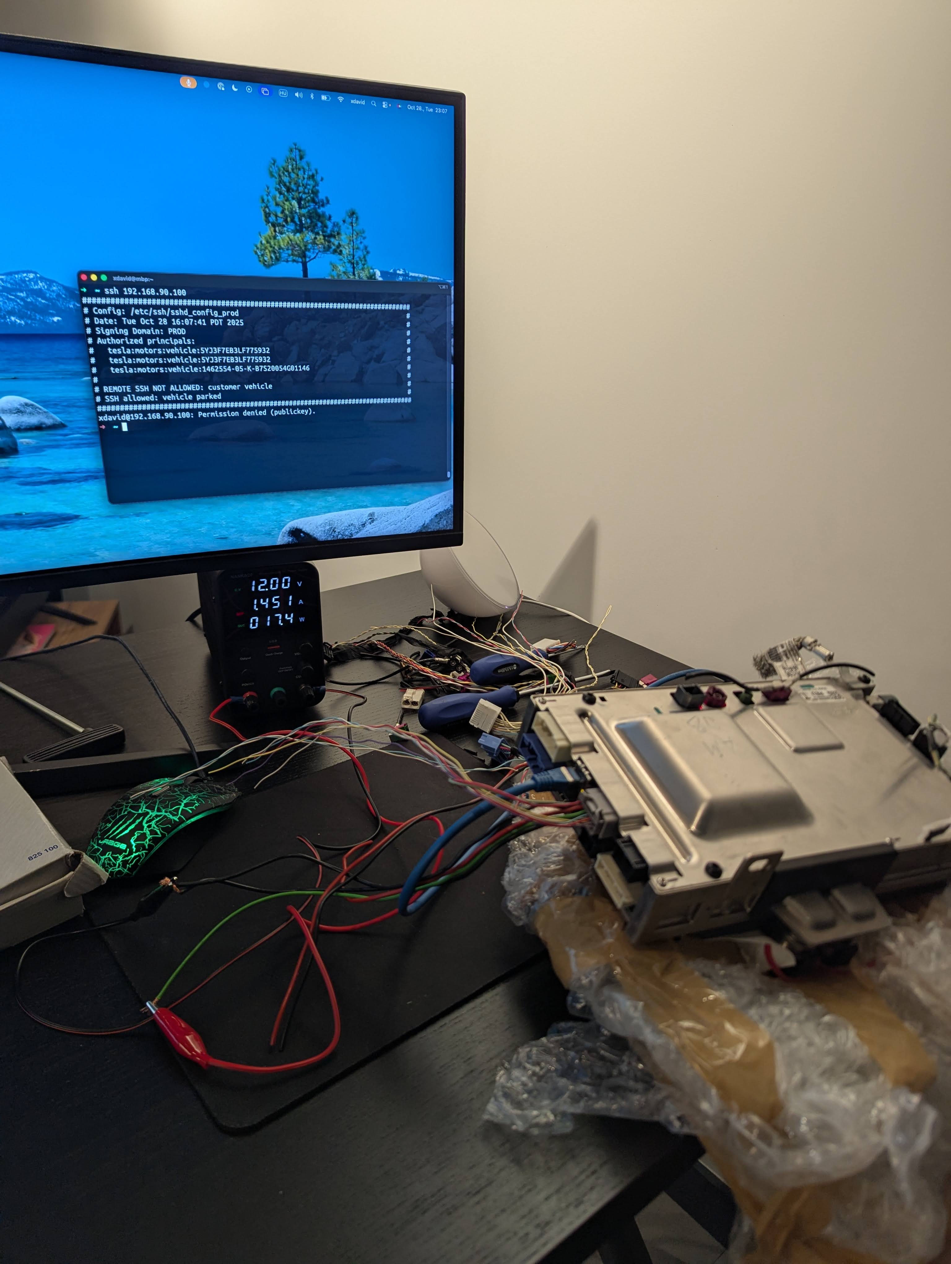 Tesla MCU bench setup — boards connected to bench power supply on a desk