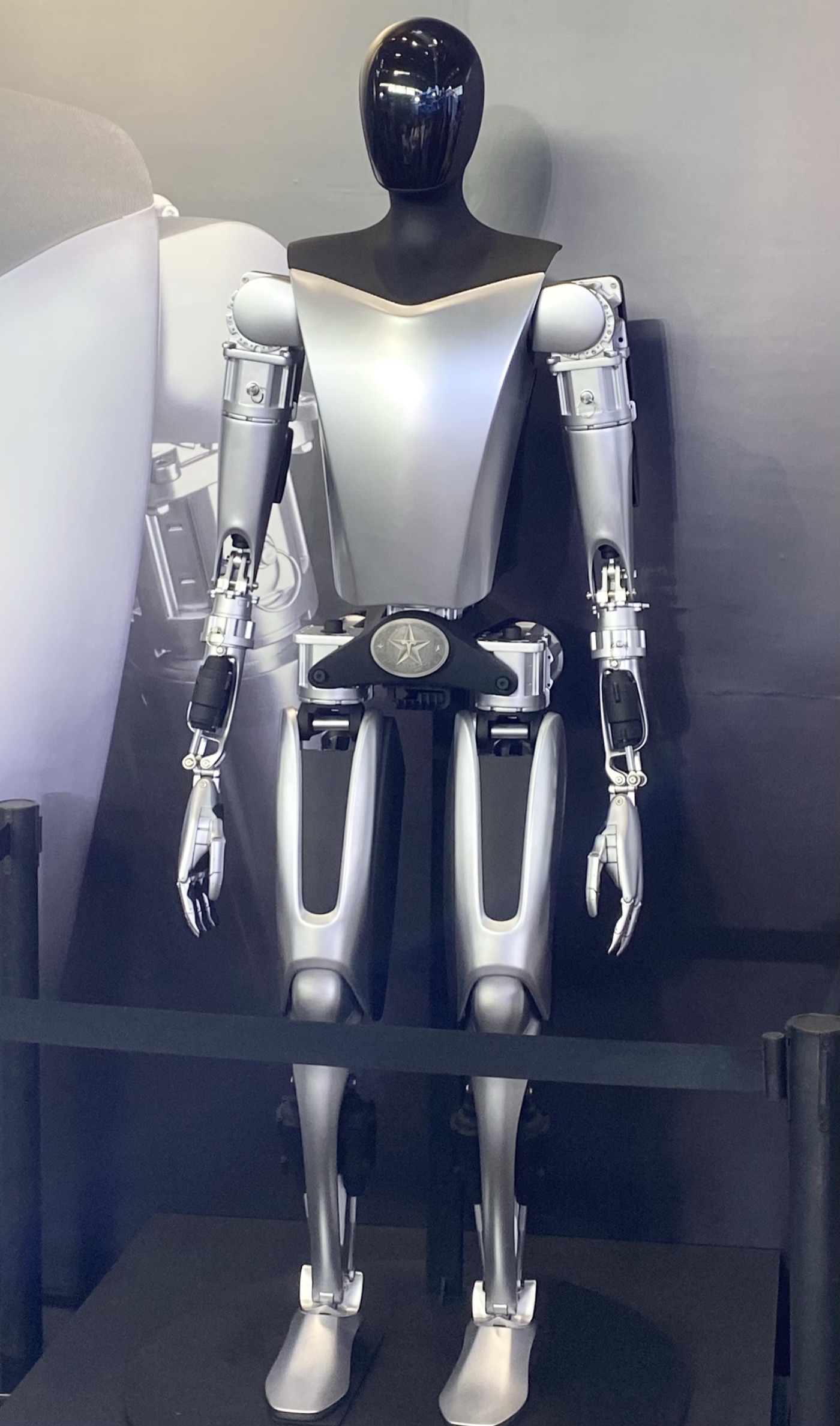 A full-body silver humanoid robot on display — the kind of commercial humanoid the 20% market-share target points toward