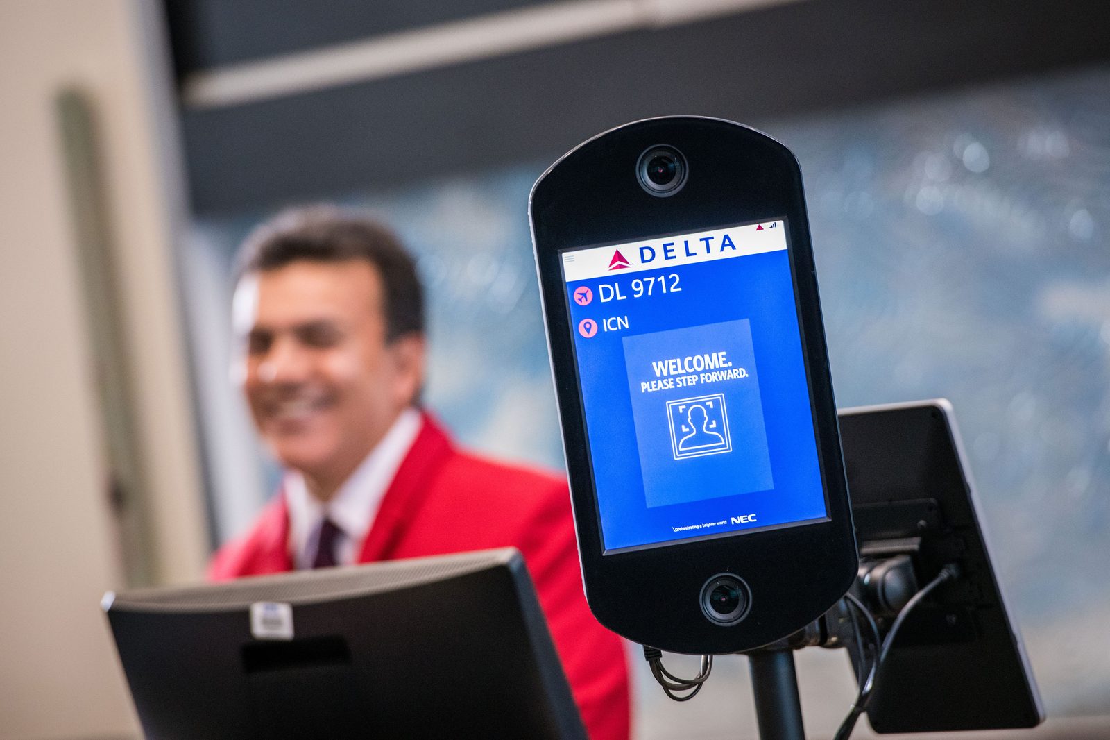 Facial recognition authentication kiosk at an airport gate — biometric AI identifying people in everyday use