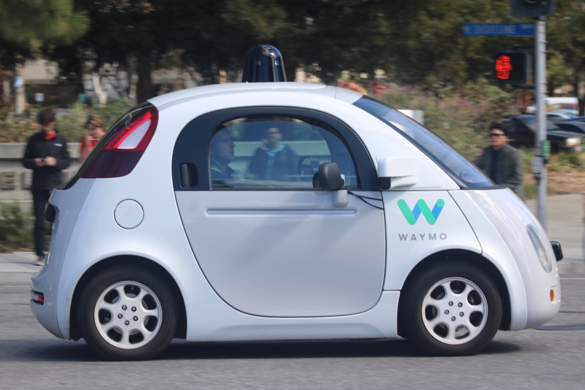 Waymo self-driving car navigating a road alongside pedestrians in Mountain View, California — a real-world example of mixed traffic