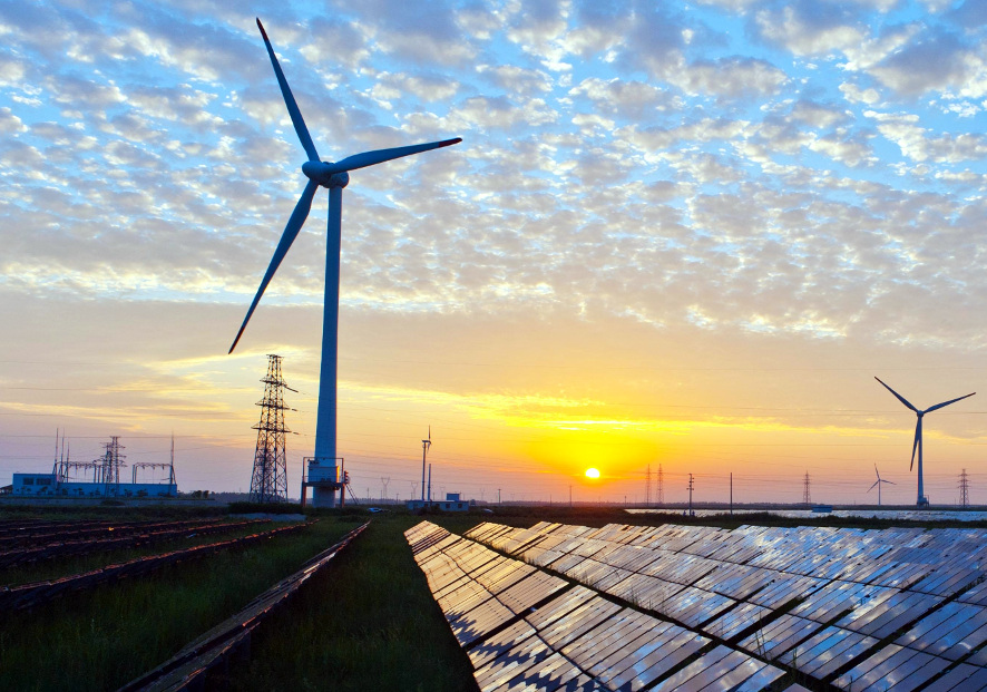 Wind turbines and solar panels at sunset — mixed renewable energy generation